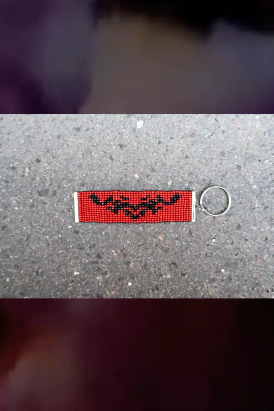 Red beaded keyring with a black bat motif